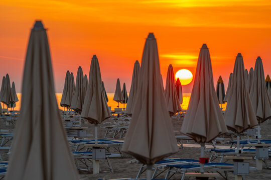 View of sunrise and sunshades on the Lido on Rimini Beach, Rimini, Emilia-Romagna