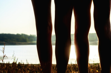 male and female legs without clothes on the river bank