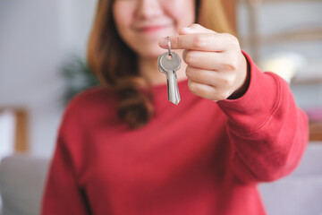 Closeup image of a young woman holding the keys for real estate concept