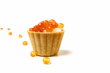 Red salmon caviar. Red fish roe with butter on a tartlet. White tableware with a blue pattern. Raw seafood. Elite delicacies. Protein healthy food. White background. 