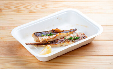 Sea bass fillet. Healthly food. Takeaway food. On a wooden background.