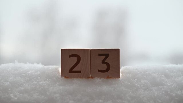 Air temperature in winter, close-up of a wooden cube with a 23 degrees fahrenheit sign.