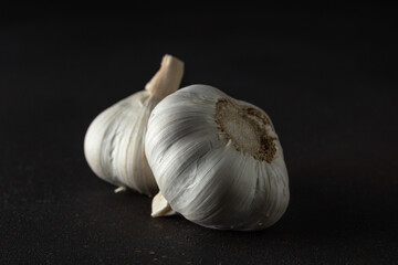 Whole garlic bulb on black background. Minimal food concept.