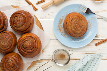 Sweet homemade cinnamon rolls on wooden background, top view