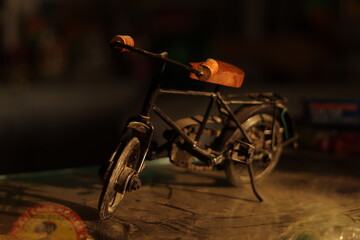 A Vintage Black Indian Iron Bicycle or cycle toy standing on a dirty glass with selective focus,...