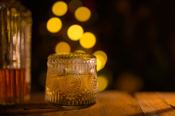 Whiskey glass with ice on a wooden table Beautiful night whiskey with alcohol copy concept on colorful bokeh night background