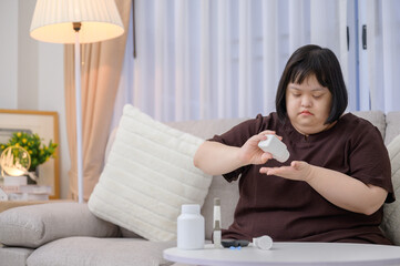Asian fat woman disabled with Down syndrome A diabetic patient is taking diabetes medicine at home
