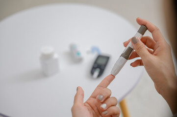 Close-up photo of diabetes test A diabetic patient is having blood drawn on his finger to test his diabetes with a home blood sugar meter