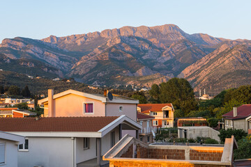 View of a small village with mountain houses on the mountain crest in Bar city Montenegro. Sunset - obrazy, fototapety, plakaty