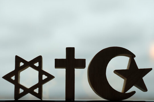 Christianity, Islam, Judaism, the three monotheistic religions in symbols of Jewish Star, Christian Cross and Islamic Crescent, France