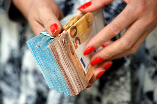 Woman holding euro money banknotes, concept of stealing cash, rich people, savings or spending money, counting payment