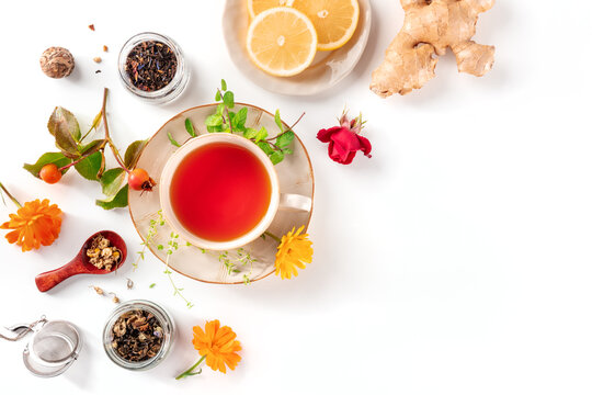 Tea with various ingredients and copy space. Herbs, fruits, and flowers, overhead flat lay shot on a white background. Healthy natural remedies