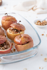 Baked apples with granola and ice cream. Apples on a dark background. Oatmeal in apples.