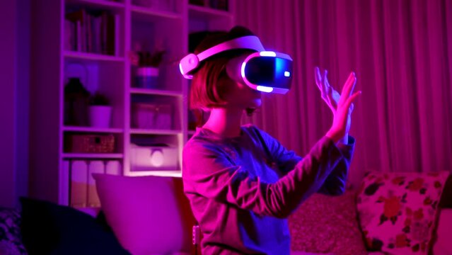 Pretty teenage girl wearing virtual reality headset in a dark room. Cute teen using VR glasses to play a game. Child in virtual augmented reality helmet. Future technology concept.