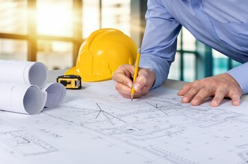 Businessman or architect with safety helmet on the desk
