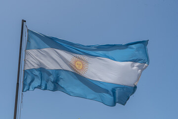 Argentine flag flying in a blue sky