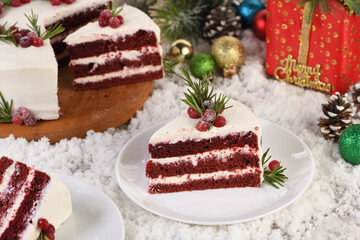 Red Velvet Cake is a traditional red chocolate cake topped with white buttercream and decorated with a Christmas wreath of candied cranberries and rosemary.