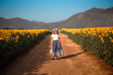 Asian Woman in the sunflowers field. Summer time.  Happy woman, enjoying warm weather
