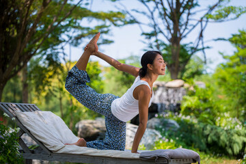 Young woman practicing yoga in the nature .Yoga is meditation and healthy sport concept relaxing with green nature background