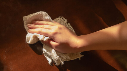 ウエスで拭き掃除をする女性の手