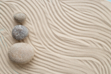 Fototapeta na wymiar Zen garden meditation sandy background with stones for relaxation and hatmony