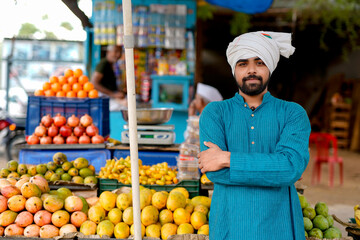 Young Indian fruit seller selling or showing his fruit