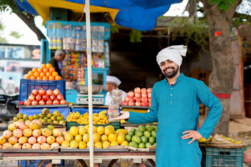 Young Indian fruit seller selling or showing his fruit