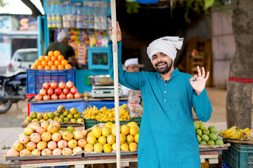 Young Indian fruit seller selling or showing his fruit