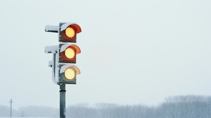 Snow Covered Traffic Lights Showing Amber Warning Signal On Winter Day