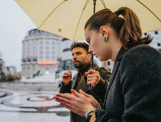 Young business people collaborating on a rainy day in the city.