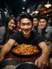 Fototapeta premium At a family New Year's dinner. Happy young Asian people sitting in a restaurant and taking photos.