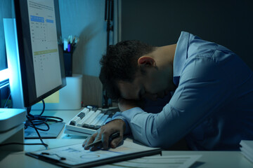 Young Asian businessman experiences stress, headaches, eye strain and fatigue while working with...