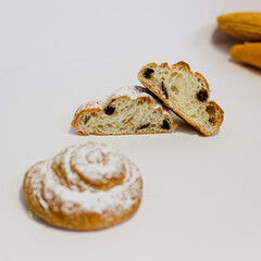 Caracola con trozos de chocolate sobre fondo blanco. Caracola abierta por la mitad en la que se ven los trozos de chocolate. Fotografía de producto de panadería pastelería. 