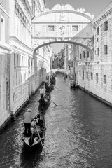 Black and white view of a row of gondolas under the famous Ponte dei Sospiri, Bridge of Sighs in Venice, Italy	