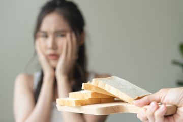 food intolerance concept, young women anxiety before eating bread worrying about gluten intolerance in the bread. - obrazy, fototapety, plakaty