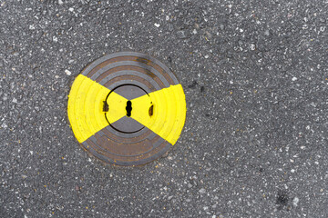 Gas utility manhole cover with yellow paint on asphalt