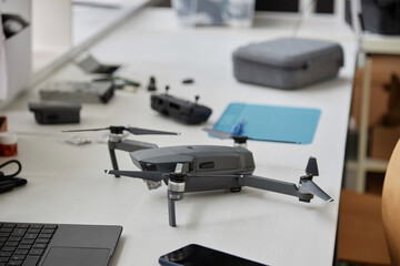 Close up of quadcopter drone on table in tech repair workshop, copy space