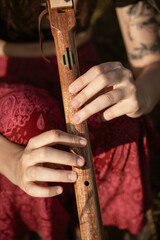 Close up of a woman playing a native american flute in sunset light