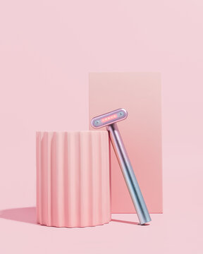 Red light therapy skincare wand on pink background