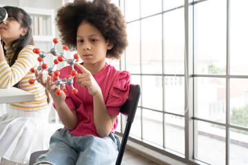 Mix race kid girl funny learning study science of holding atom model at learning class