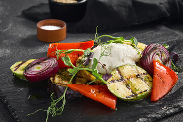 A medley of grilled vegetables paired with a smooth cheese mousse, artistically plated on a sleek...