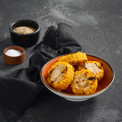 Charred and juicy grilled corn on the cob presented in a rustic orange bowl, an ideal summer barbecue dish