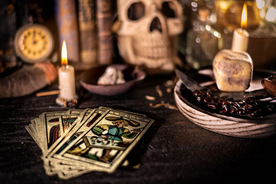 Un altar místico cubierto de objetos esotéricos, con cartas de tarot, una calavera, libros antiguos preparado para prácticas de brujería. Desenfoque selectivo.