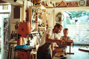 Father and daughter enjoying woodworking together in a home workshop
