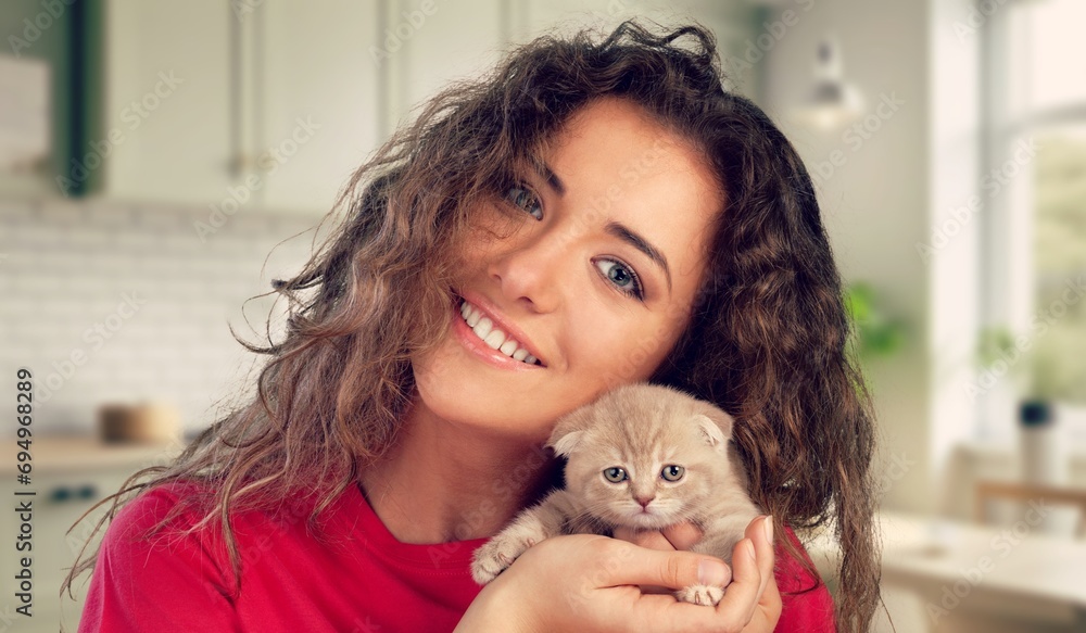 Poster Portrait of young woman holding small cat.