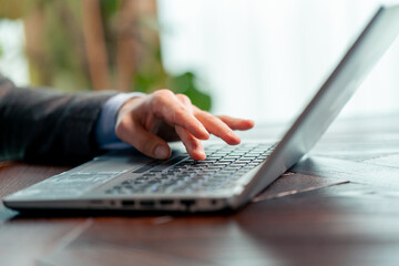 close-up of male hands of businessman pressing on laptop keyboard freelancer technology finance and business