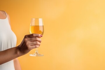 Glass of orange wine in the hands of a girl. Copy space. Alcoholic drink tasting. Romantic evening aperitif. Wine glass closeup.