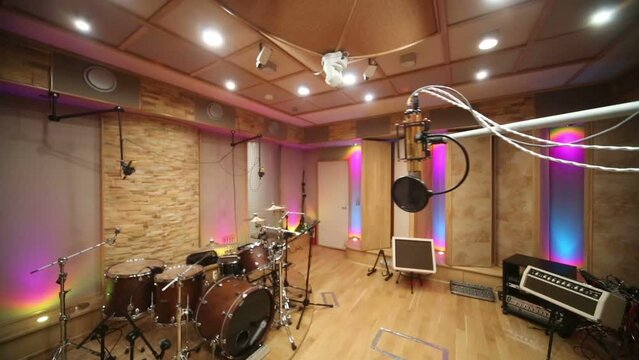 recording studio with drum set, speakers and moving microphone