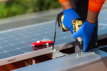 close up hand using drill driver equipment on structure. Engineer man is working to construct solar...