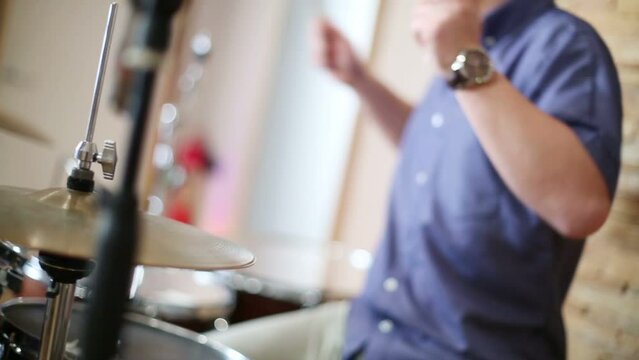 Hands of young man playing drums in modern recording studio 